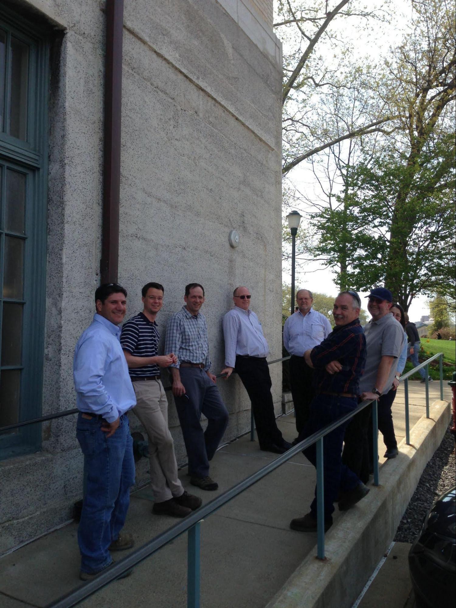 A group of men stands in front of a building.