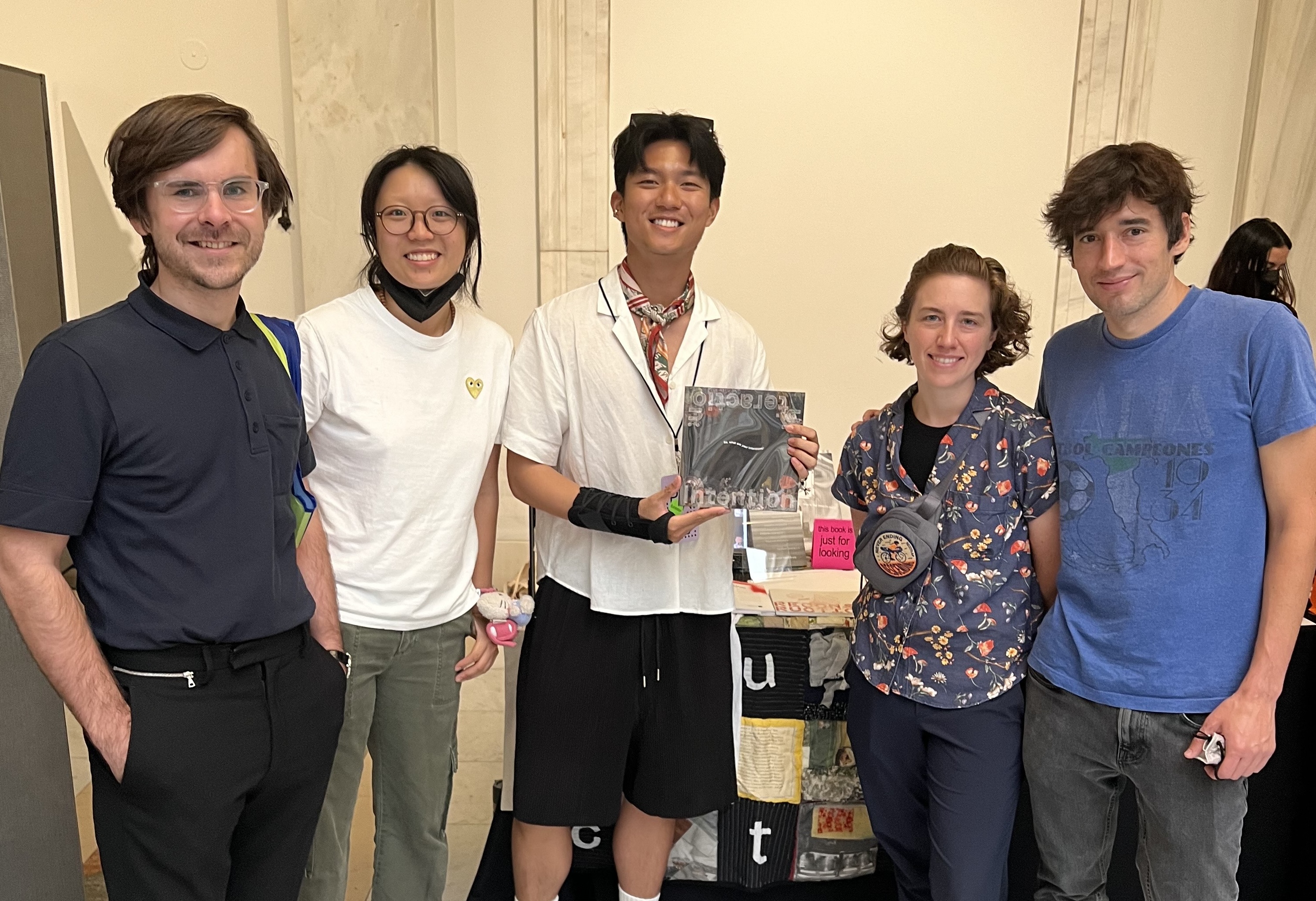 Five people pose with a book at the Pittsburgh Art Book Fair.