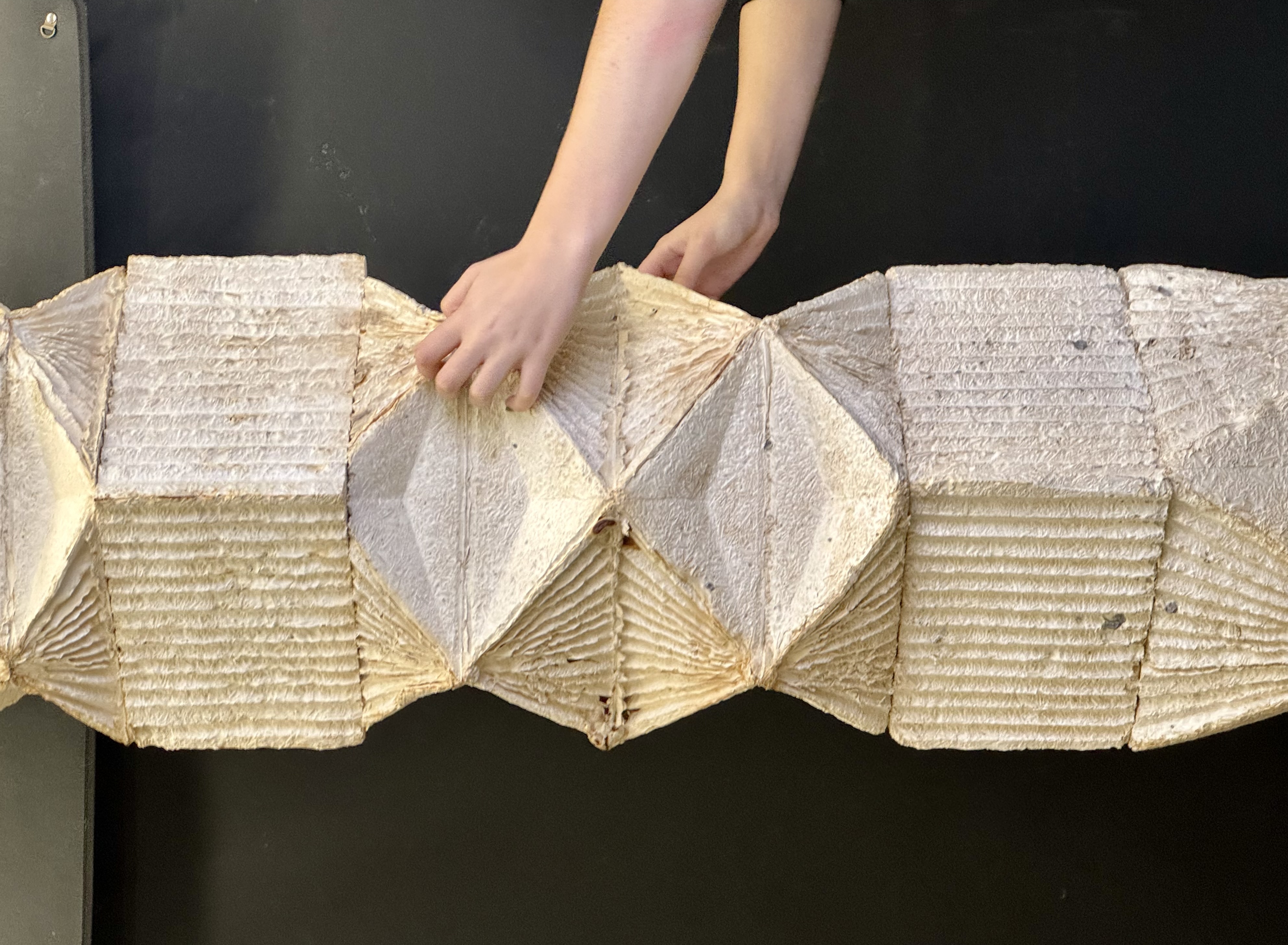 close up of two hands holding a folded paper-like object
