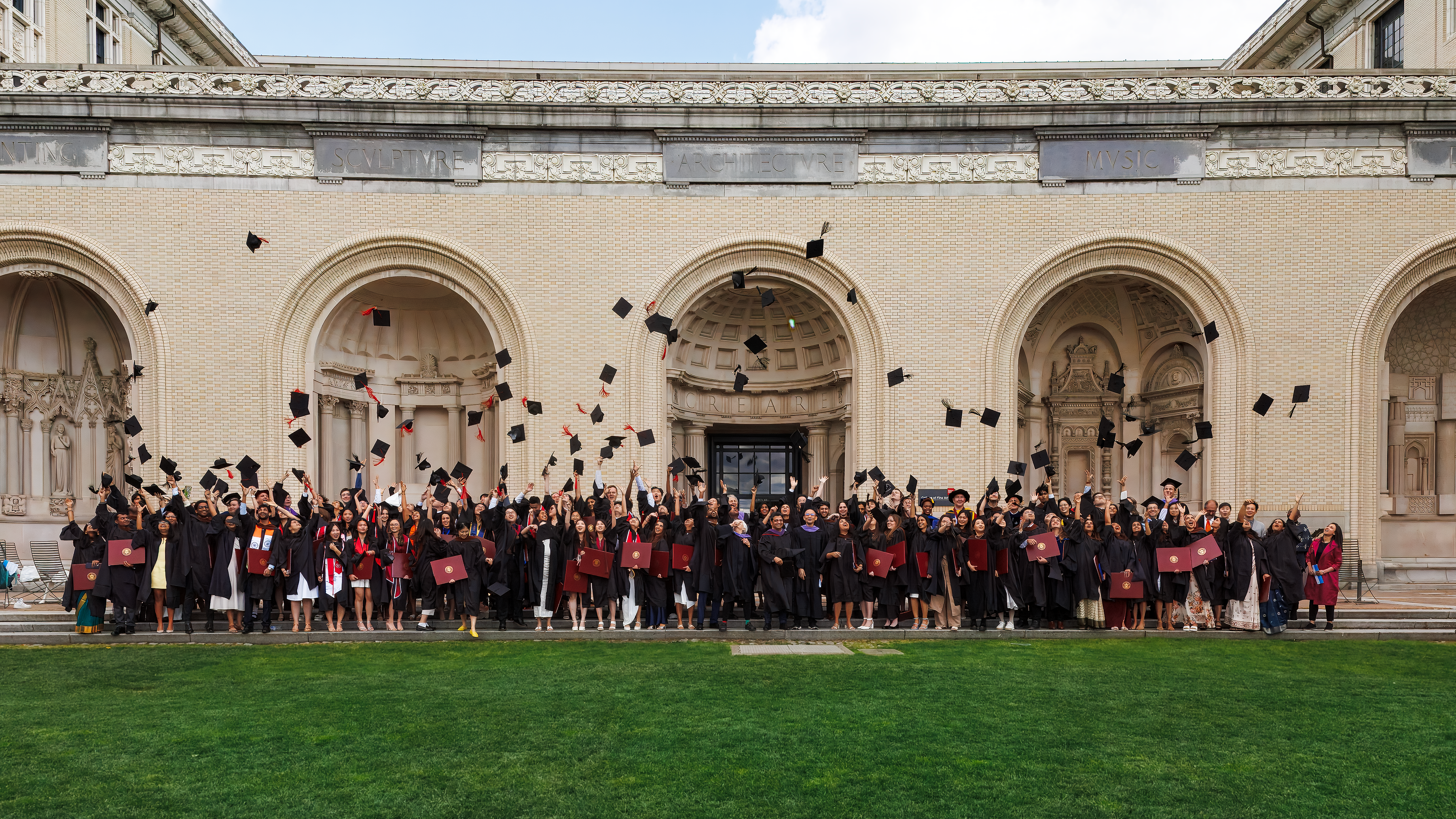 graduates throw their caps on the CFA lawn