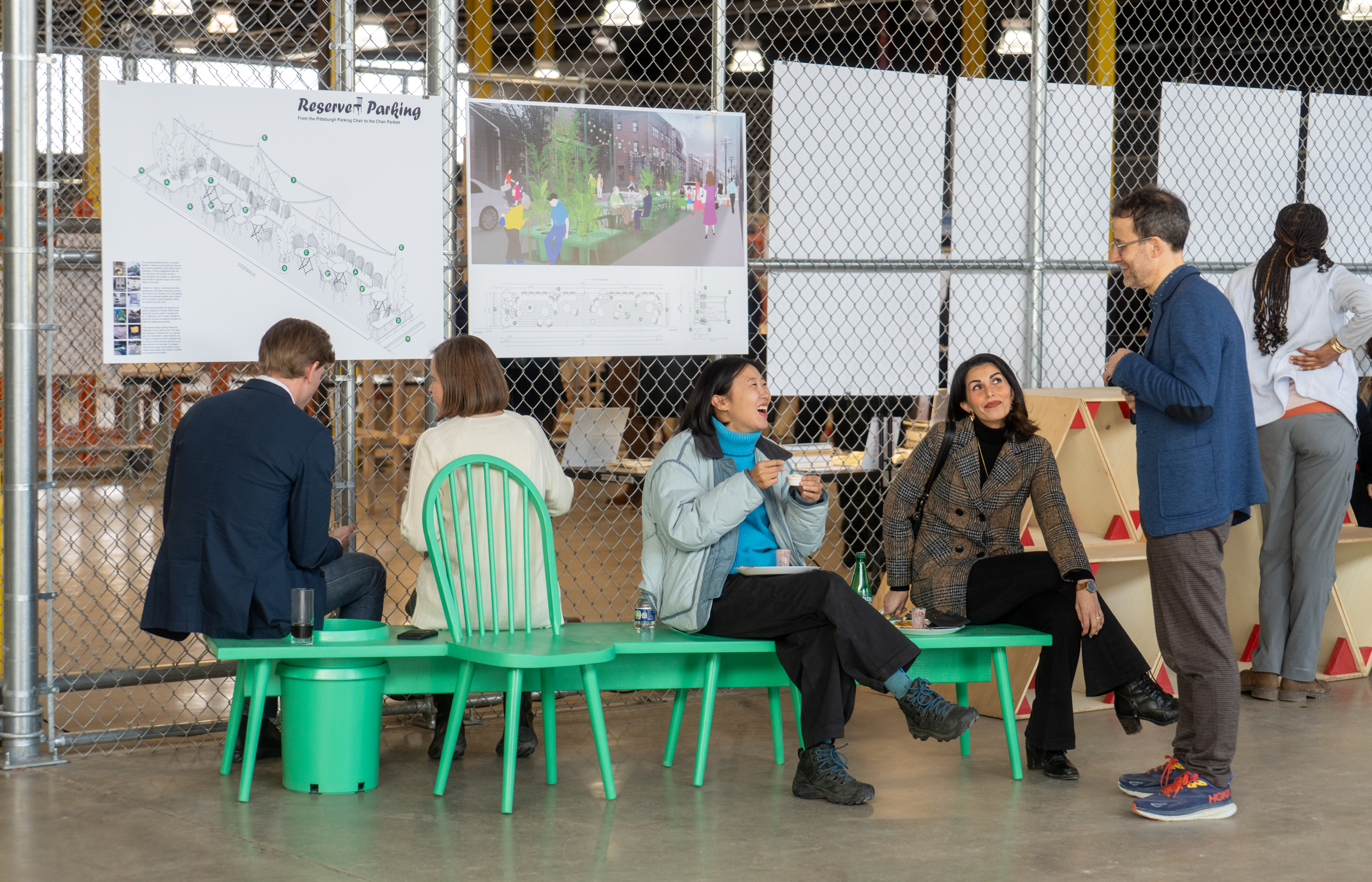 a group chats on a bright green bench.