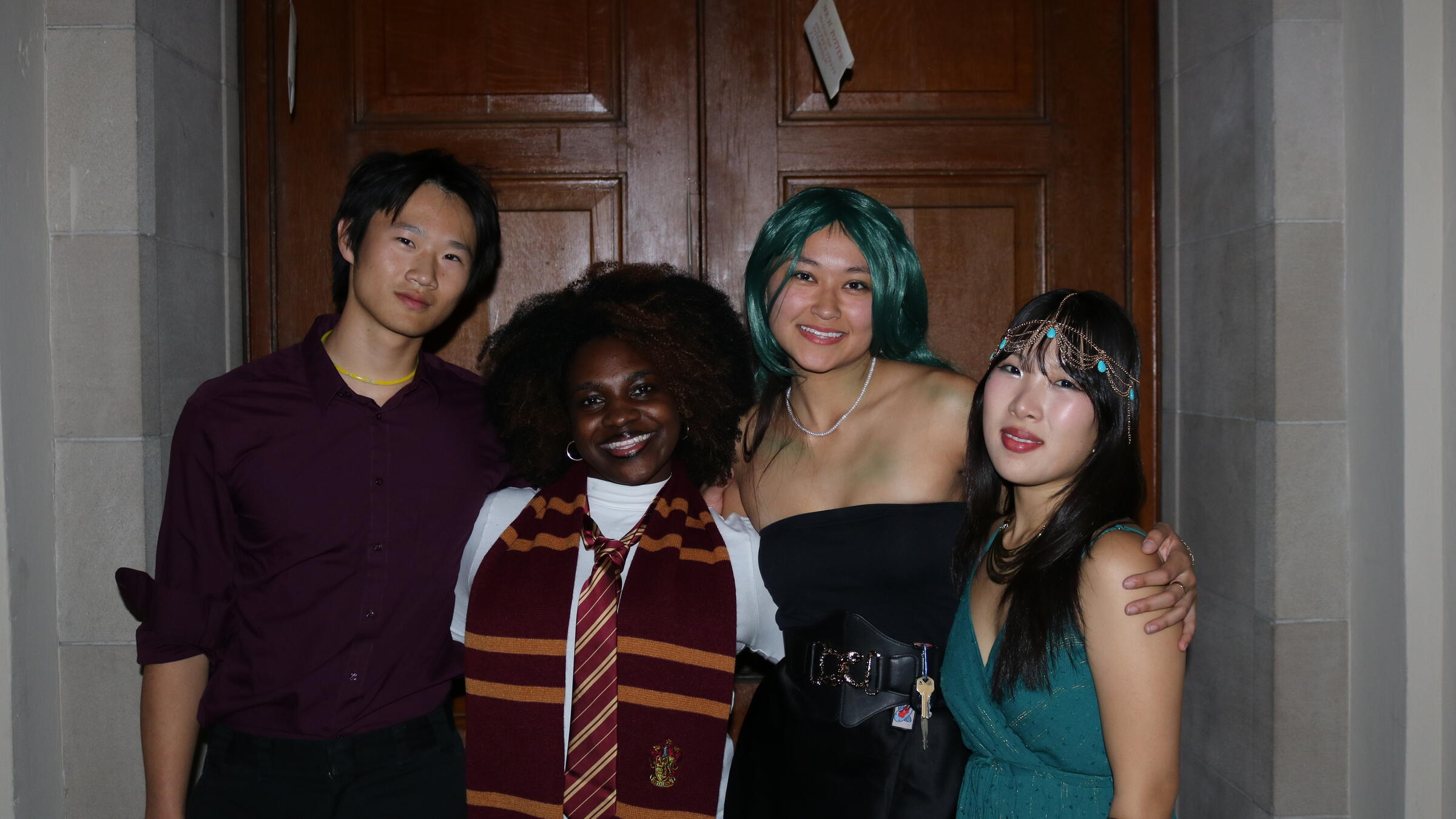 four students in costume pose for a picture