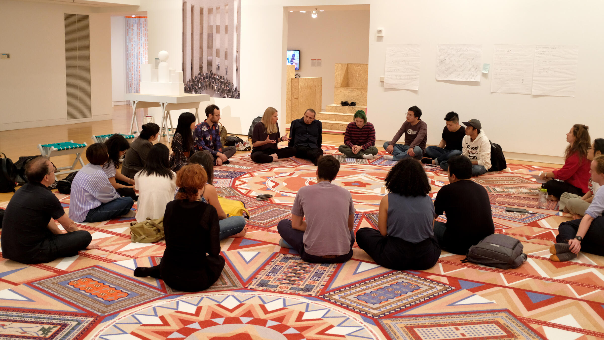a group sits in a circle in a carpeted room