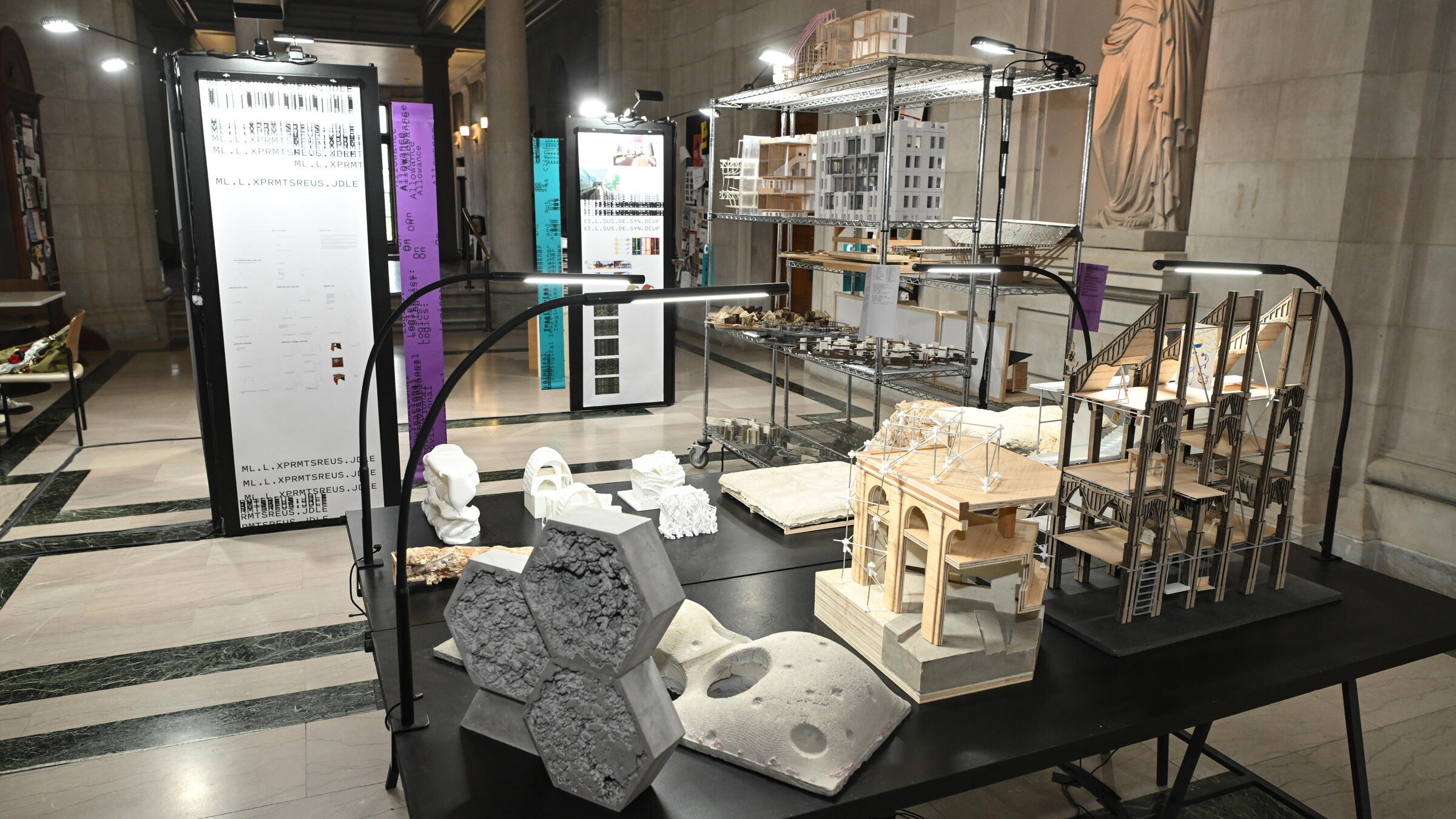 a table with models on it; in the backgrounds are displays as part of an exhibition in the great hall.