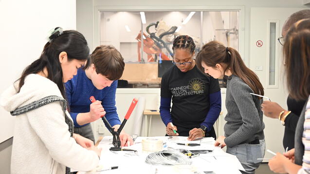 Small group around a table collaborating on a robotics project.