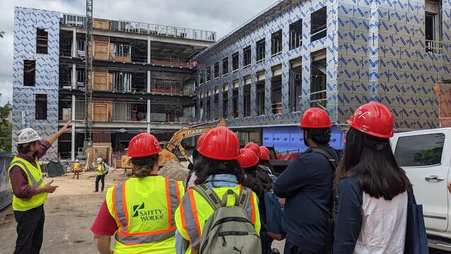 Group wearing hard hats and safety vests on a construction site