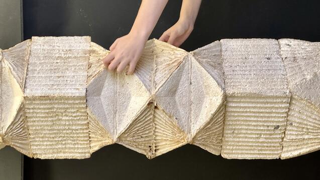 close up of two hands holding a folded paper-like object