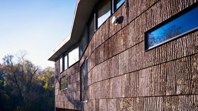the exterior of a building clad in shingles made of bark