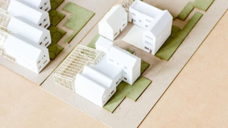 student models of white buildings on a piece of wood