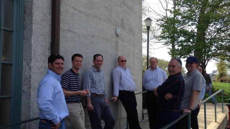 A group of men stands in front of a building.