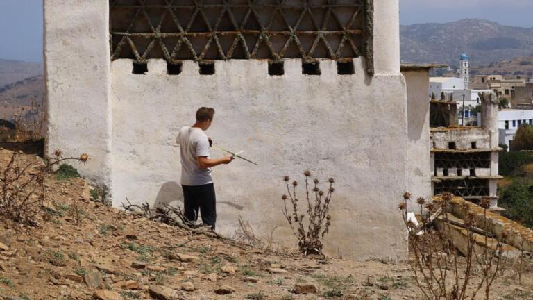 a person with a tape measure next to a white building