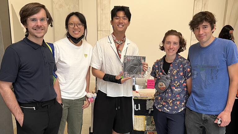 Five people pose with a book at the Pittsburgh Art Book Fair.