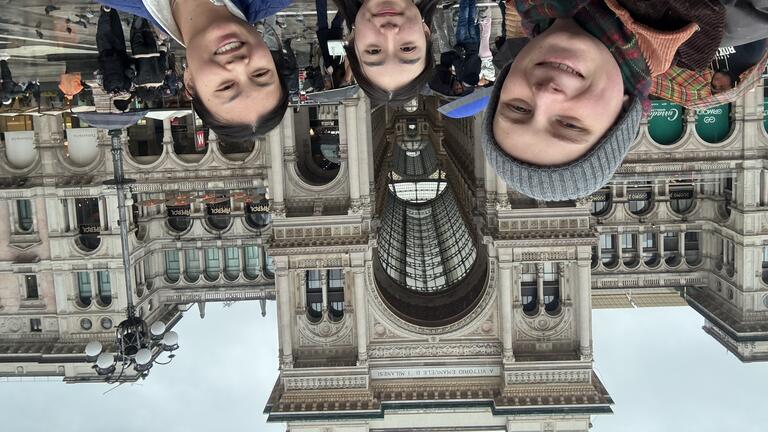 three people stand in front of a historic building in Florence, Italy