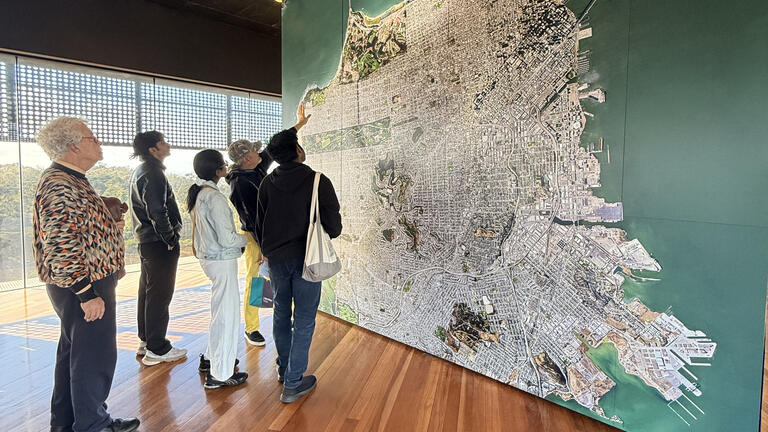 students gather around a large wall map of San Francisco