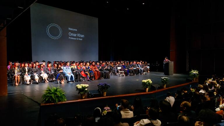 graduates process onstage