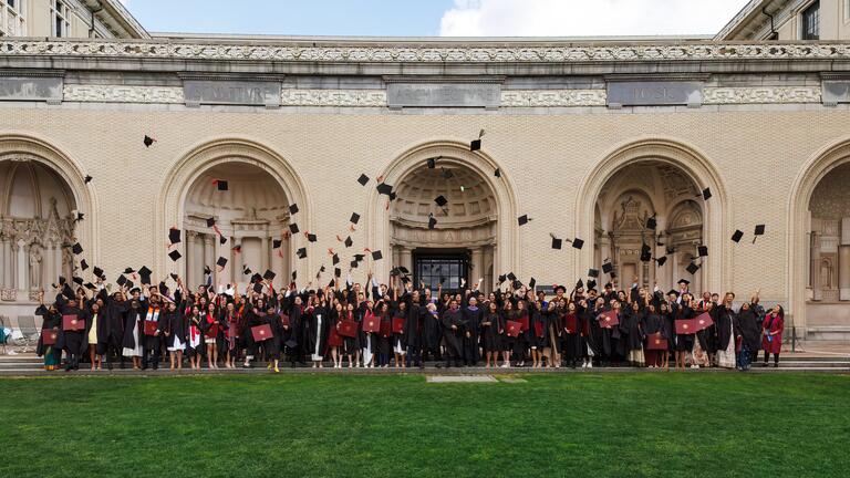graduates throw their caps on the CFA lawn
