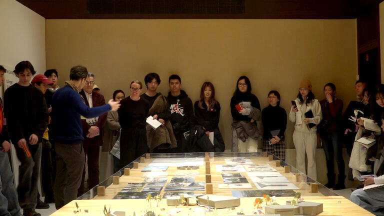 a group stands around a table in an exhibition
