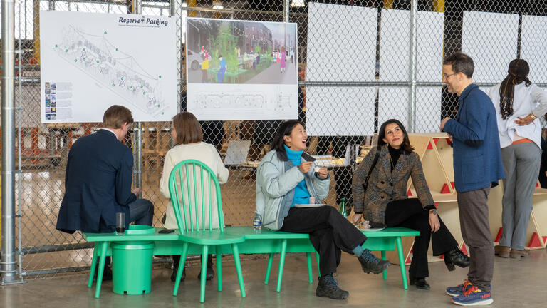 a group chats on a bright green bench.