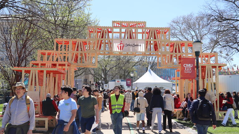 people walk under the cmu carnival pavilion on a sunny day