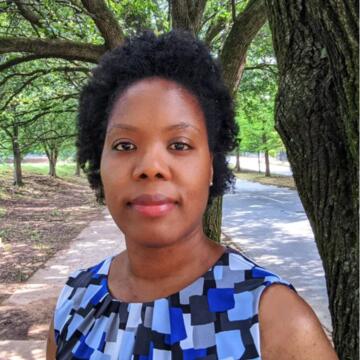 a person in a blue shirt standing under a tree