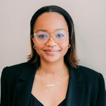 Morgan Newman headshot; woman wearing glasses and dark blazer