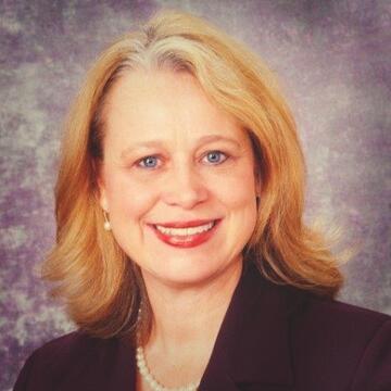 person with blonde hair and black jacket on a neutral background