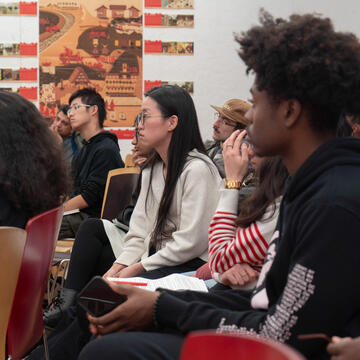 Students in audience at presentation with pin-ups in background