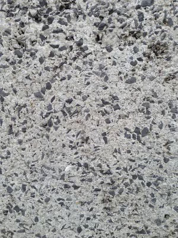 Image of CFA’s cement base, showing the white Portland cement and dark aggregate material. Image courtesy of Gerard Damiani. A detail of concrete with black aggregate.