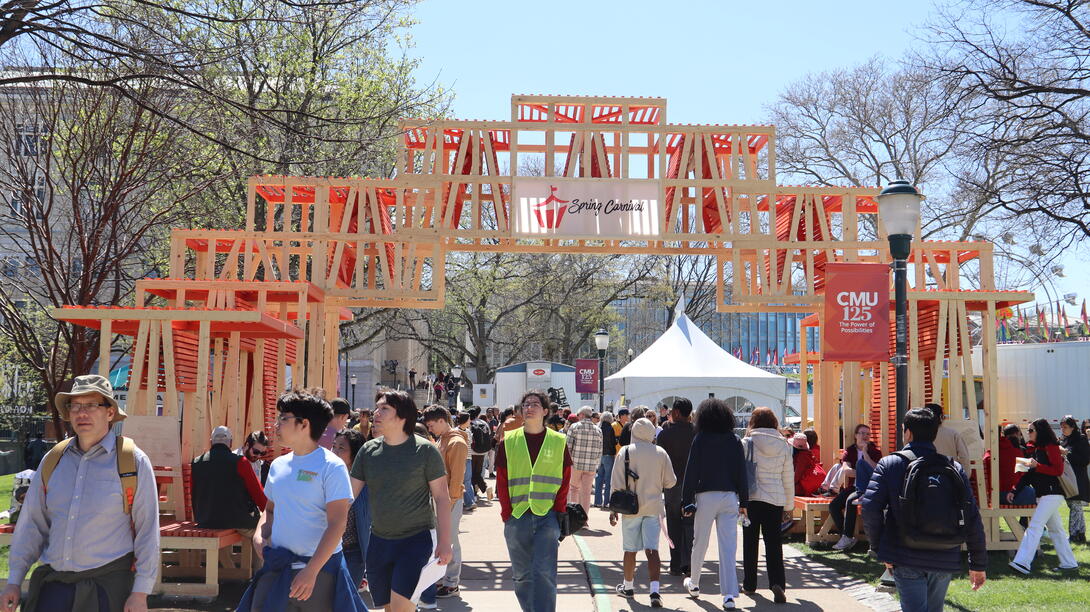 people walk under the cmu carnival pavilion on a sunny day