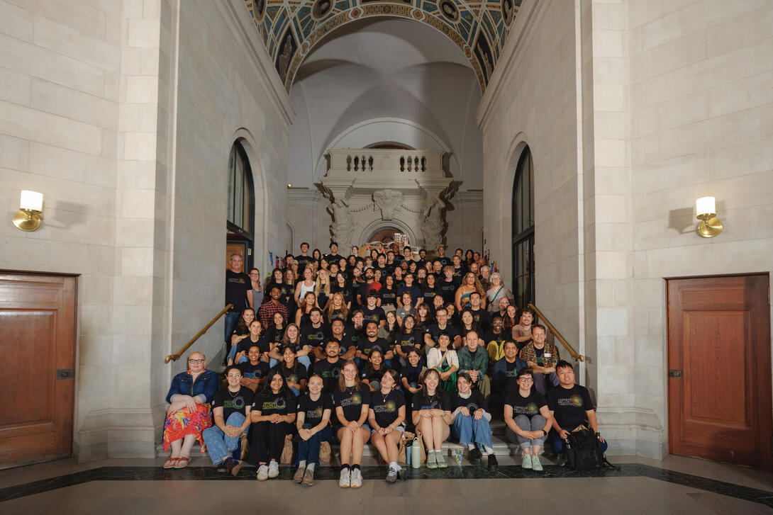 group of students, faculty and staff sitting on the steps in the CFA great hall posing for the all-school photo