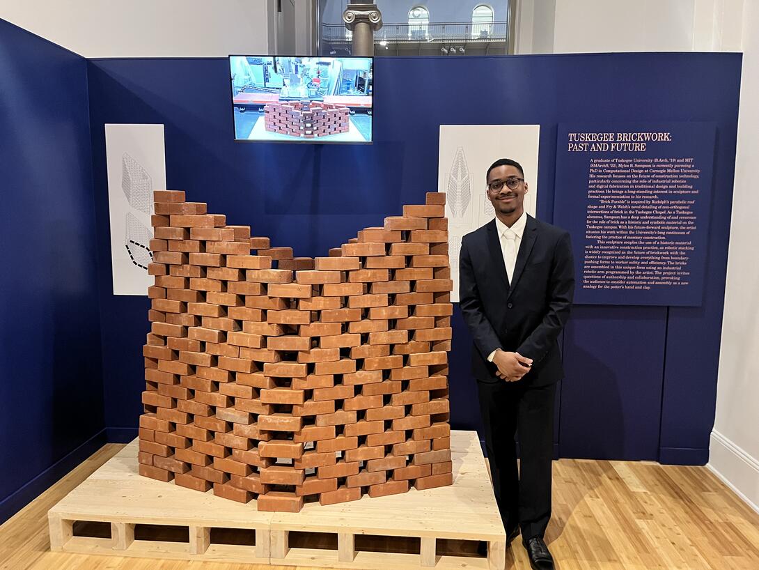 Myles Sampson (PhD-CD candidate) stands beside his project "The Brick Parable," a robotically fabricated brick installation, at the National Building Museum in Washington, D.C., in the exhibition, "Tuskegee Chapel: Paul Rudolph x Fry & Welch."